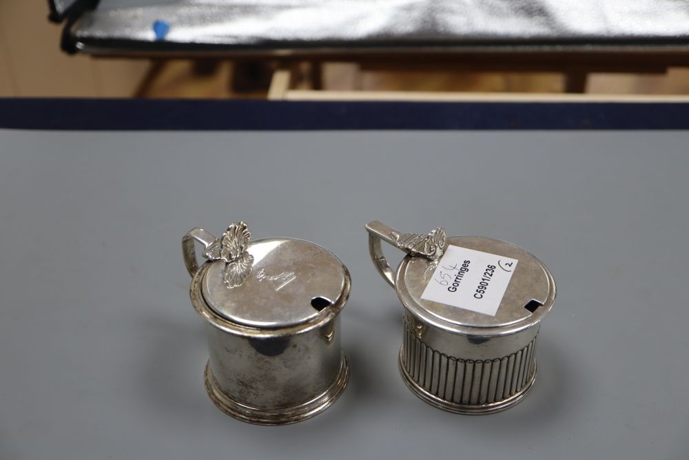 Two 19th century silver drum mustards, with blue glass liners. London, 1826 and London, 1853, tallest 7cm, 9oz.